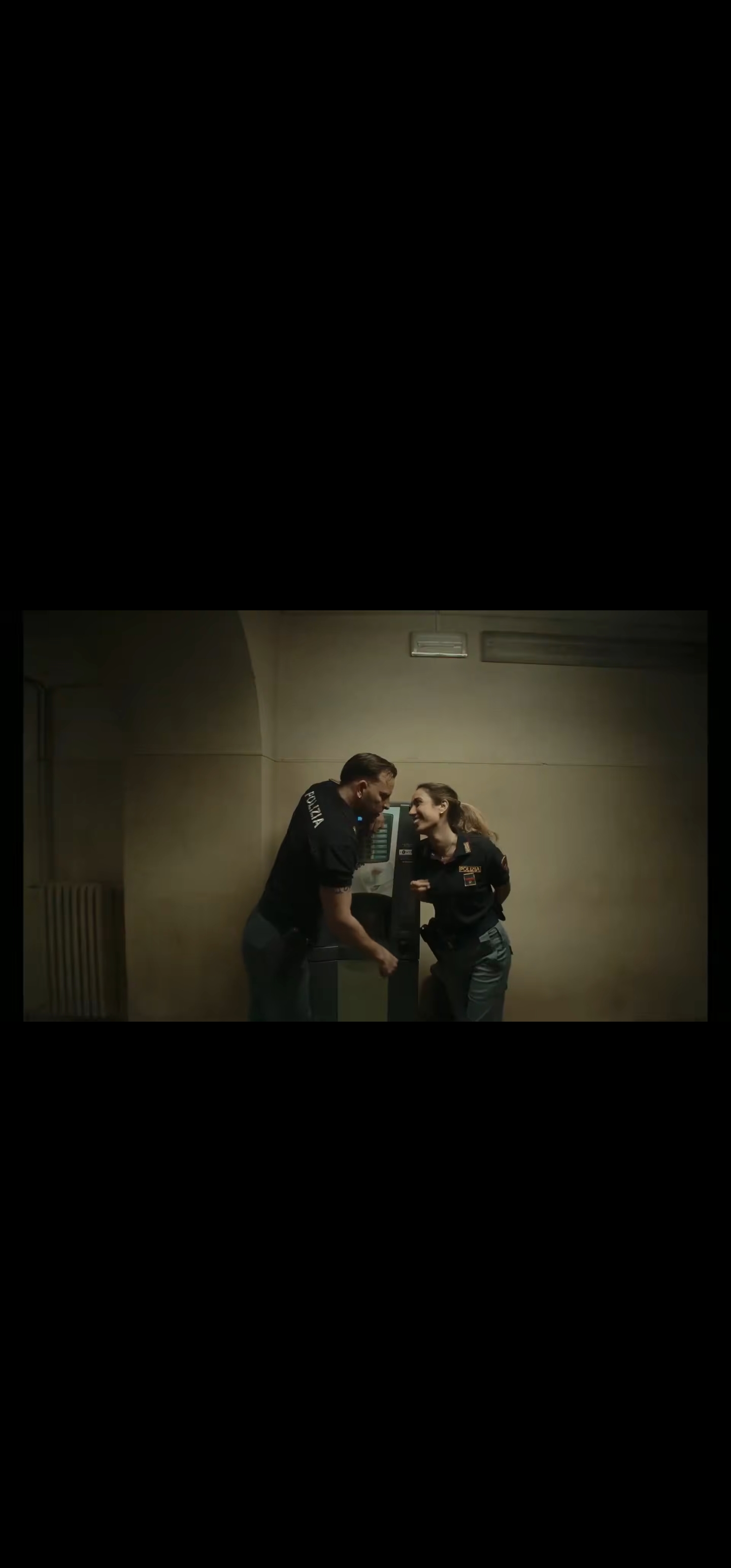 Scena di un film con due personaggi davanti a un distributore automatico